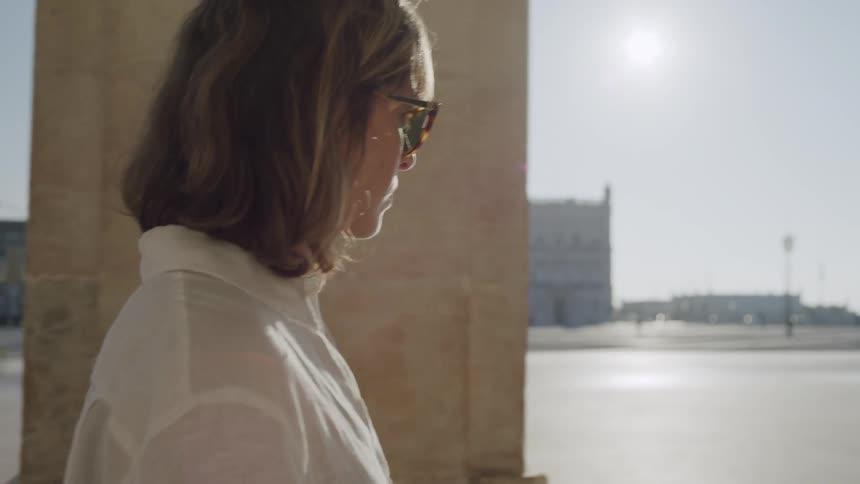 Woman with glasses walking through a public space