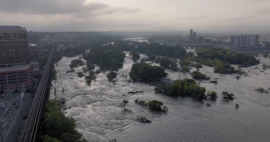 Aerial view of a city next to a flooded river with several small islands covered in vegetation