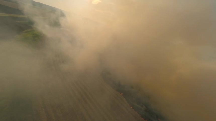 Smoke rolls over the farm with a big fire Aerial view