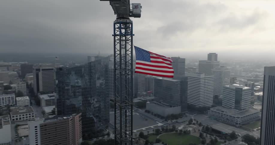 Aerial view of a large american flag hanging from a construction crane