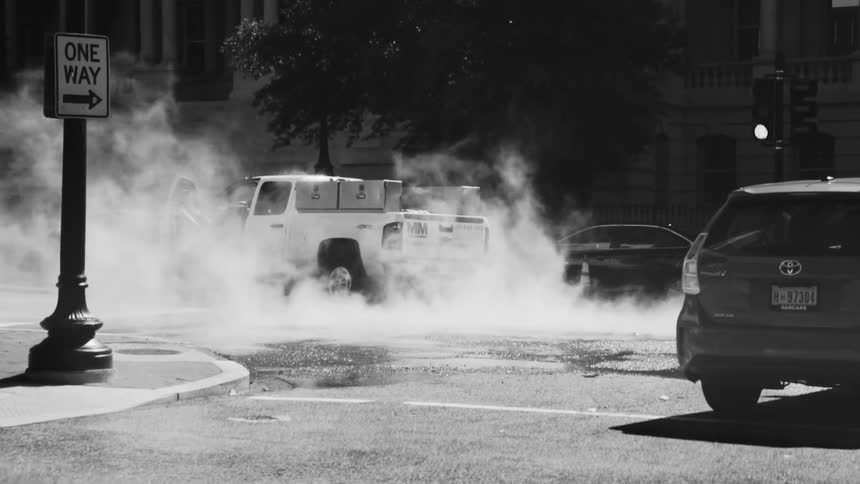 Cars driving down a street in a metropolis during the day