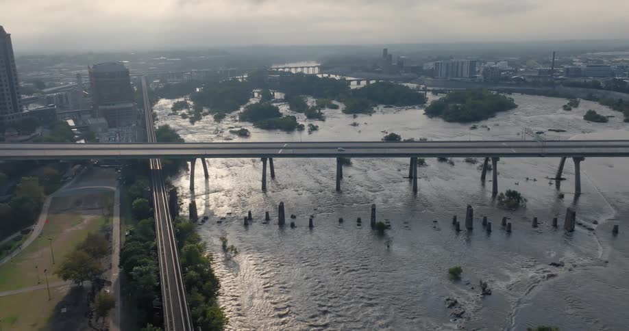 An aerial clip of a connecting bridge and a lake in a city