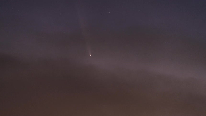 A shooting star streaks across the sky