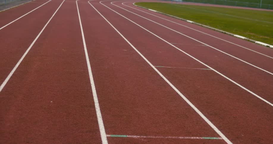 Fence encloses a running track circling around a grassy field