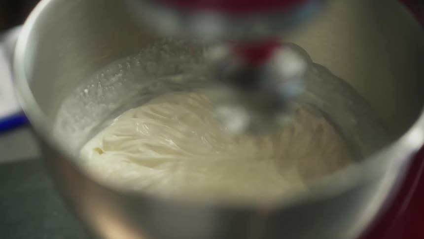 Cream is being mixed in the metal container