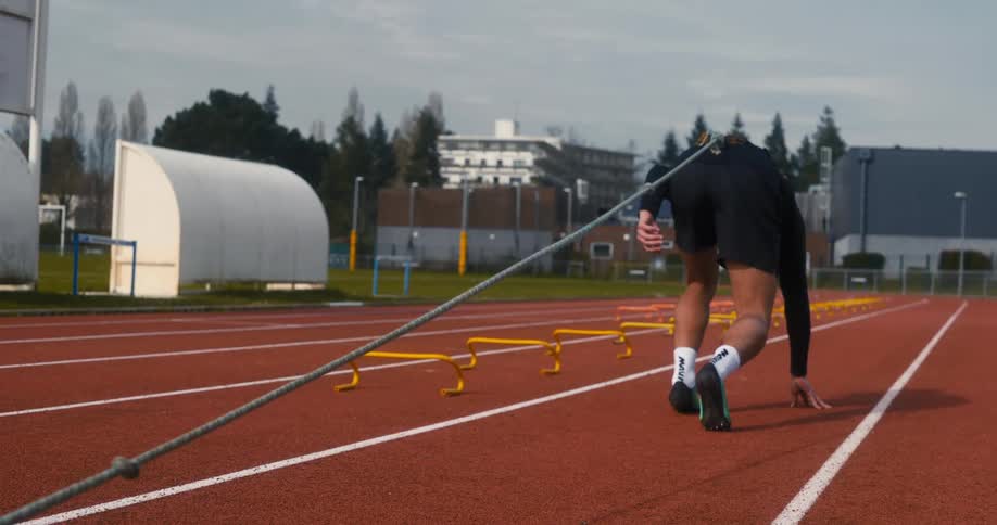 Man running on a running track with a weight tied to a rope