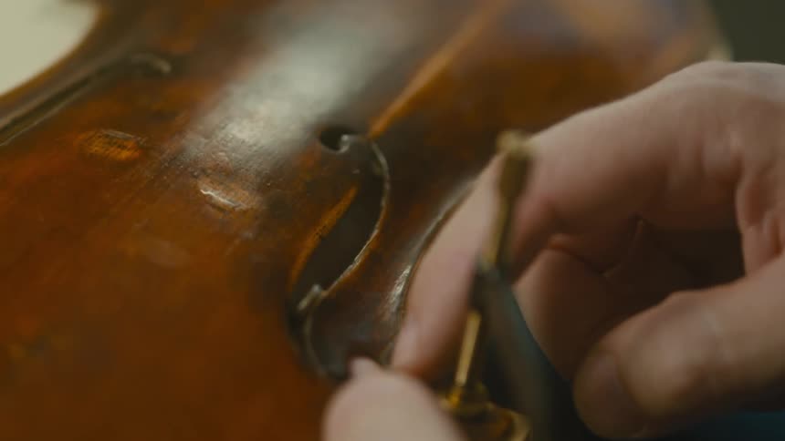 A man is repairing a cello