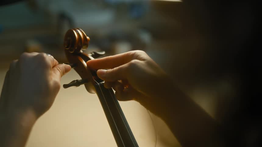 A female musician tunes her string instrument
