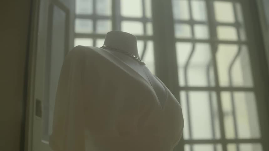 A mannequin is dressed and wearing a necklace
