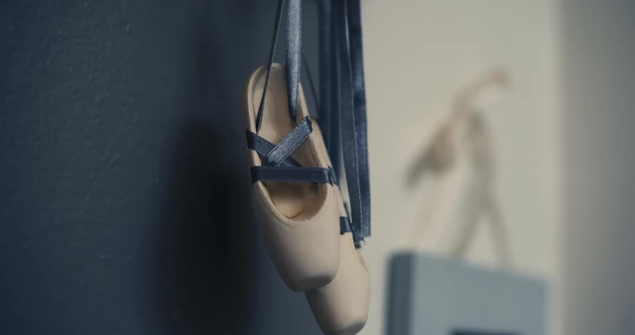 Ballet shoes hang from the door