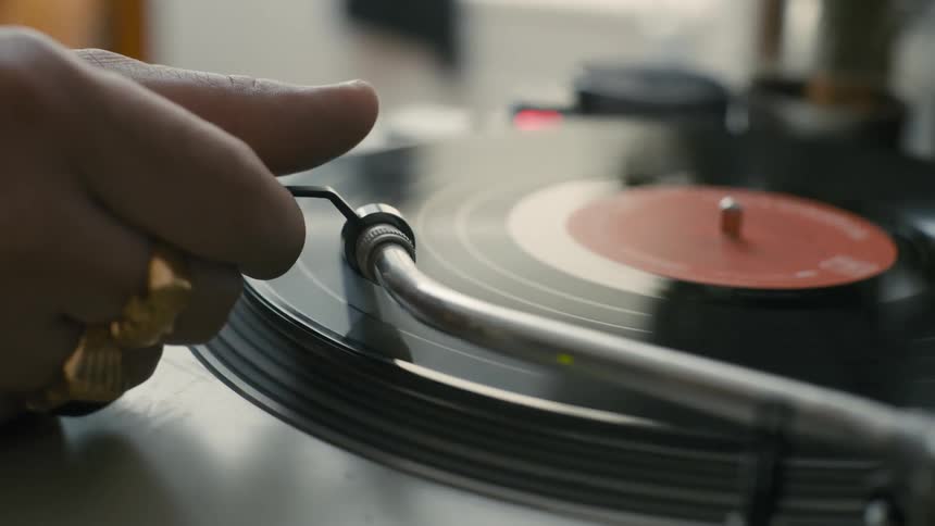 A person turns on the record player