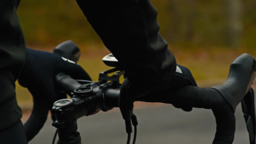 Gloved hands resting on the handlebars of a bicycle