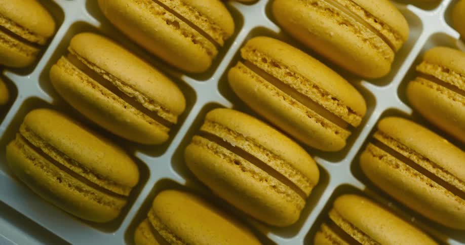 Close up of several macarons with yellow filling in the middle