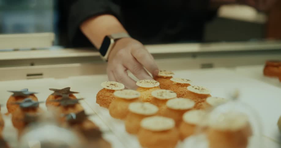 Hand placing confectionery sweets on display on a plate