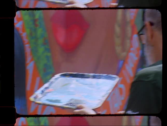 An artist painting a colorful mural captured on vintage film