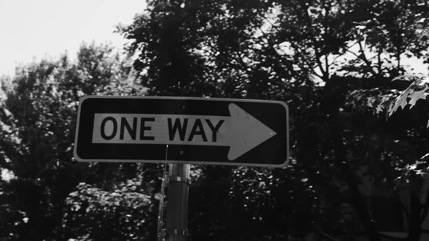 Black and white footage of a one way street sign