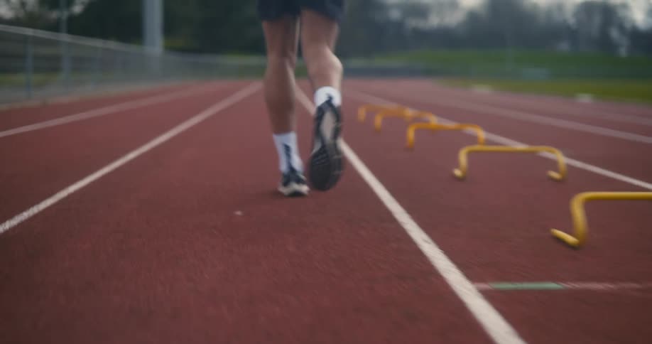 Closeup of an athletes legs as they jog on a running track
