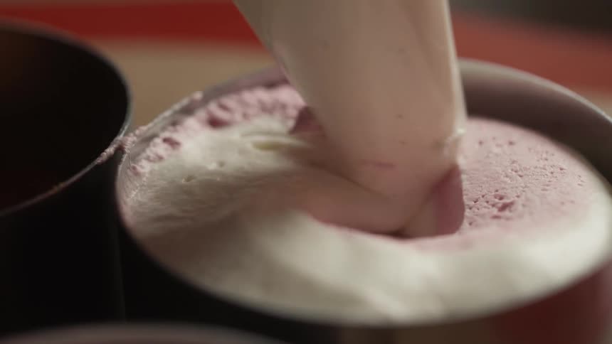 Close up of sweet cream being poured into a round metal mold