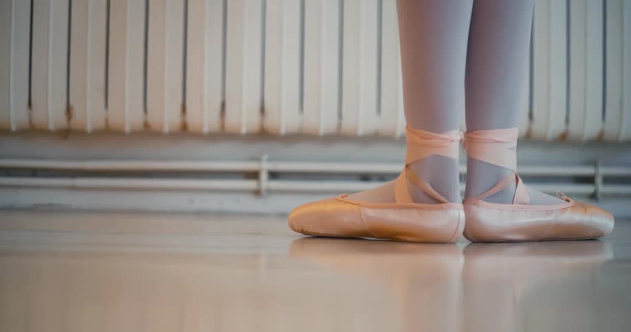 Closeup of a ballerinas feet in pink ballet shoes