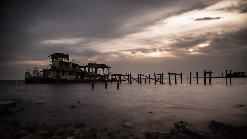 A timelapse of a tugboat sitting at a dock on an overcast day