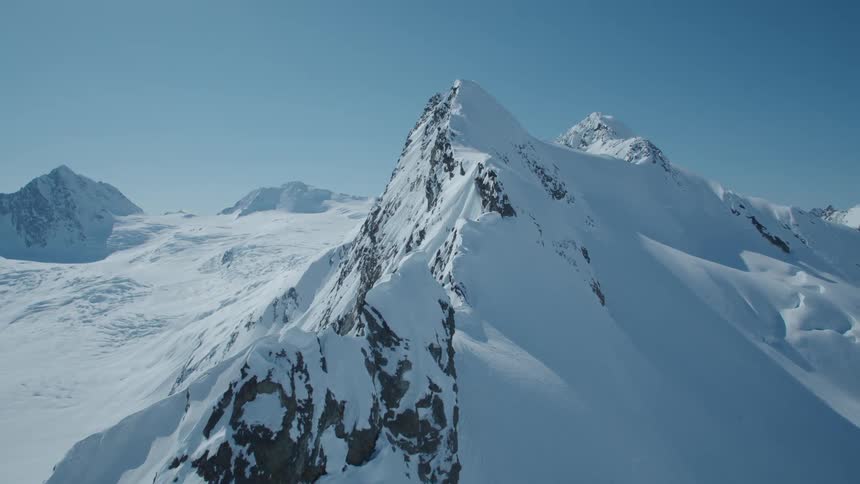 Aerial view of a cliff with mountain covered by snow