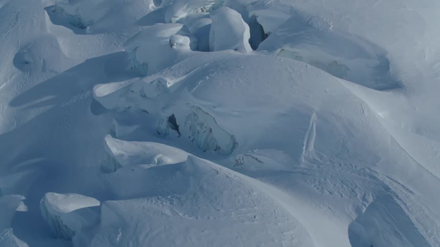 Aerial view of snow layers with crevasses seen during the day