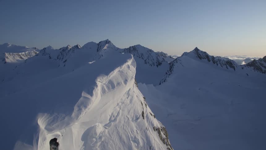 Aerial panorama of a snowcovered mountain cliff in the morning