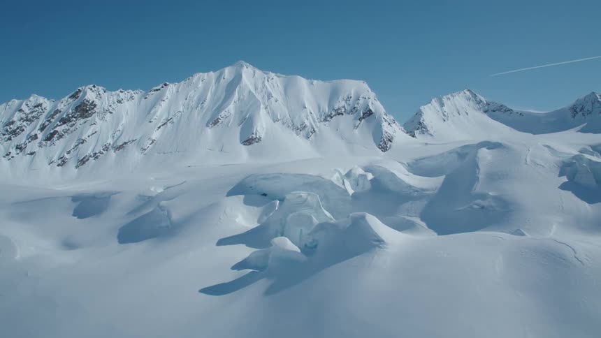 Aerial of a snowcovered mountain range on a sunny winter day