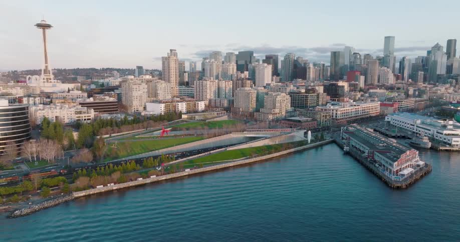 Low traverse over Elliott Bay towards Belltown and the sculpture park with the space needle visible in the distance