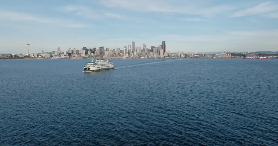 A ferry makes its way across Elliott Bay with the Seattle skyline in the distance