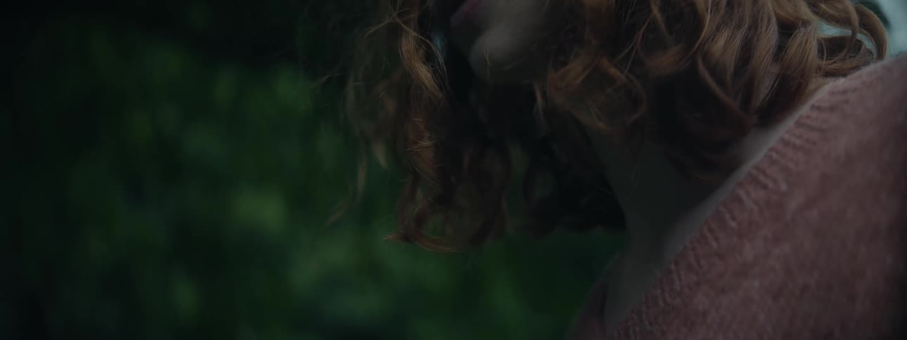 Partial face overhead view of a young curly red haired woman