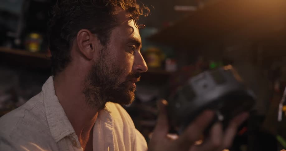 Bearded man holding a piece of metal