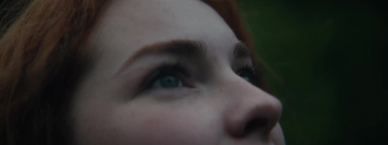 Close up of a pale woman with red hair looking up
