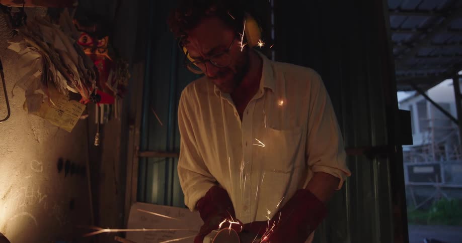 Mechanic using a cutting tool on metal sparks forming