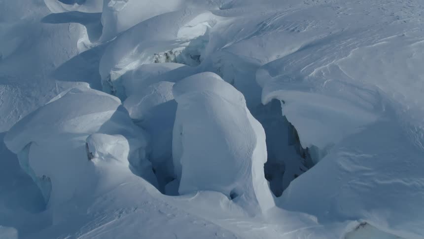 Aerial view of snow layers with crevasses