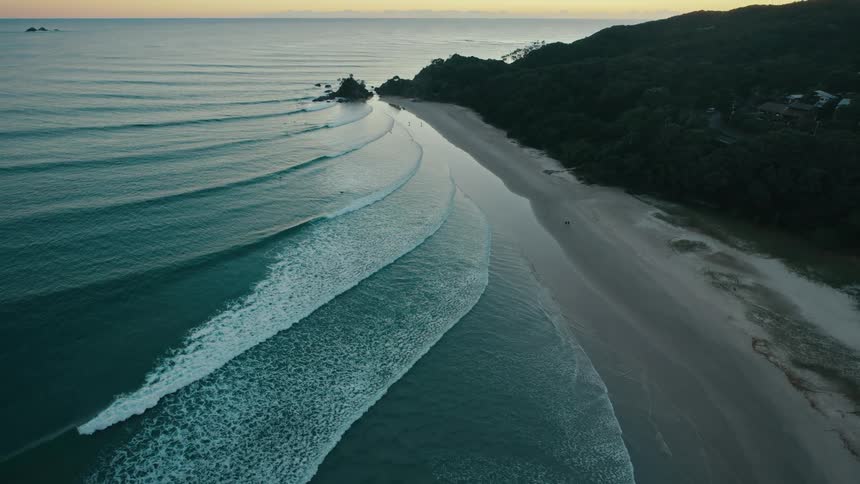 Aerial view of the beach with waves crashing onto the sand