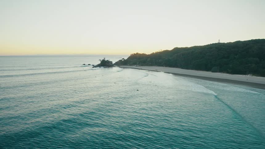 Aerial view of the sea and beach with the sun on the horizon in the morning