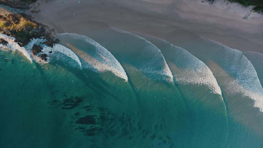 A topdown view of a beach with waves crashing on the shore