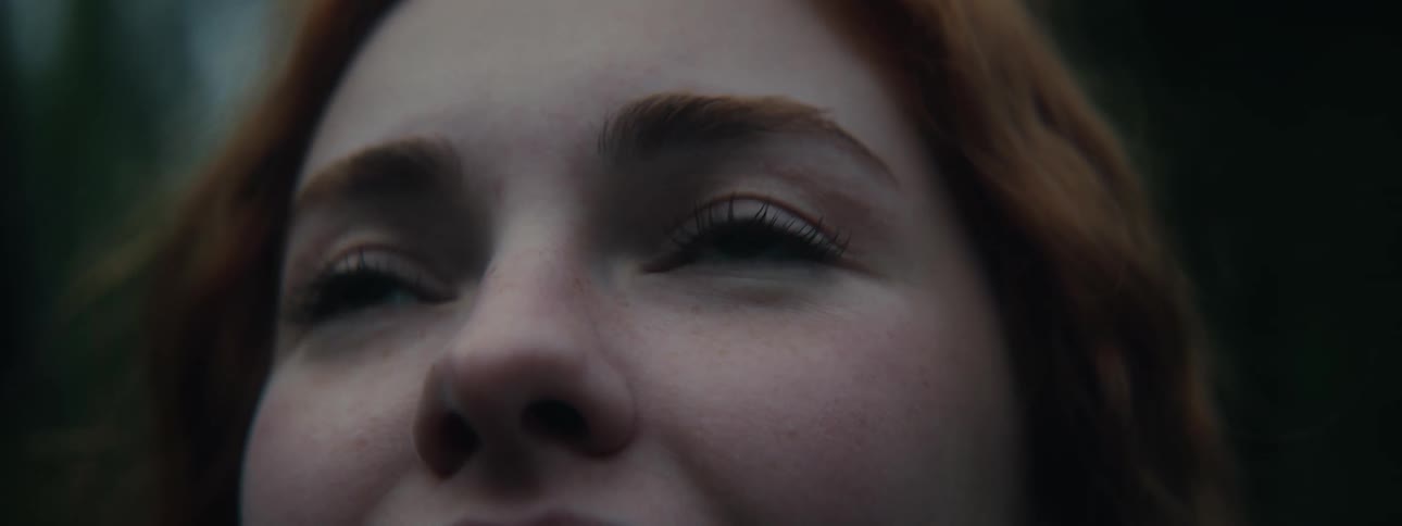 Redheaded woman smiles while staring upward
