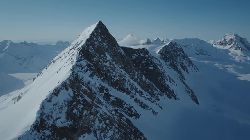 Snowcovered mountain valley against a blue sky