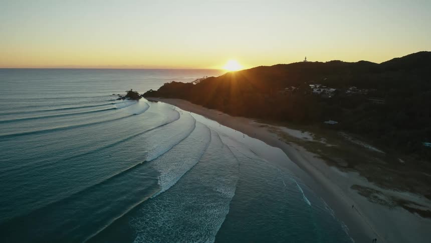 People are walking on the beach in a seaside community at sunset