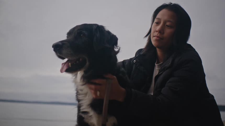 Woman crouching down petting her dog