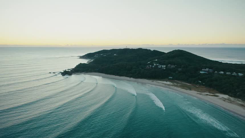 Aerial view of a beach with the coast in the background seen in the morning