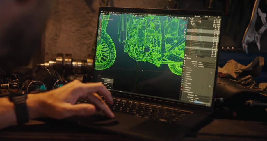Man working on a laptop with a graphic design of a motorcycle