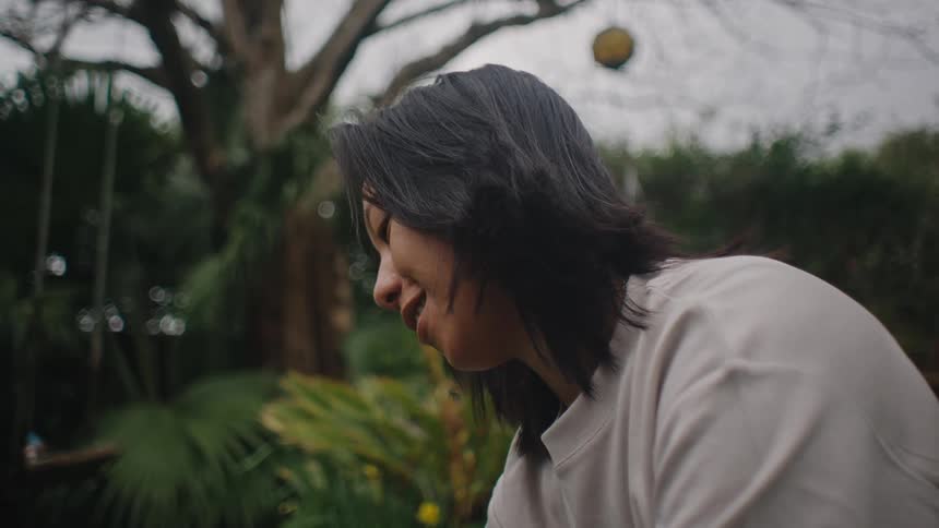 Side portrait of a woman in the garden with happy facial expression