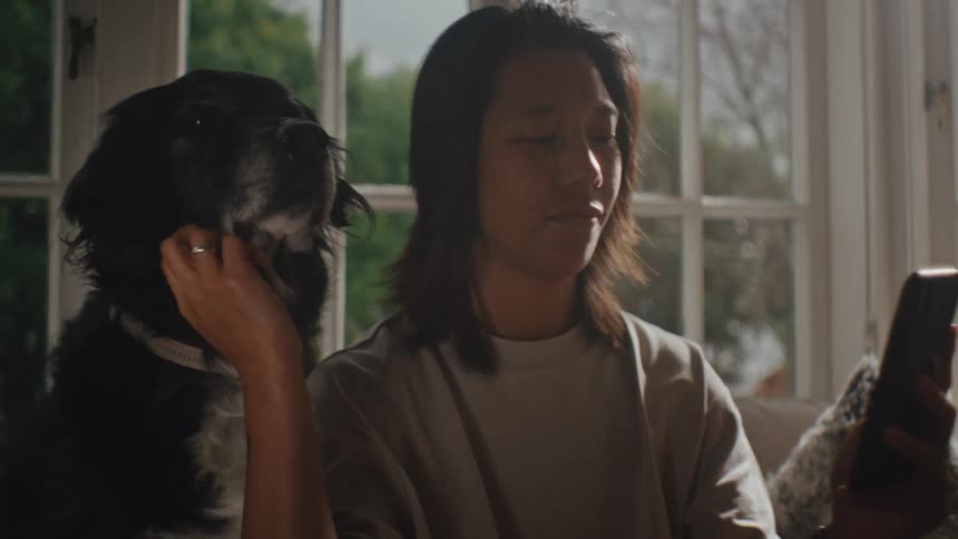 Person sitting and petting their dog