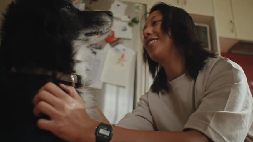 Woman petting her dog indoors