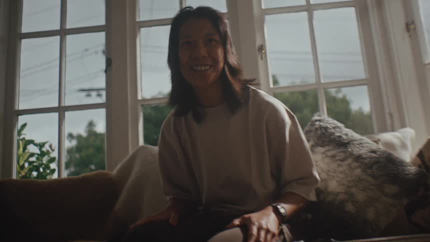 Happy person sitting on sofa in living room clapping hands on legs calling someone