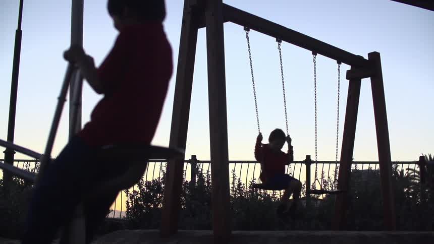 Children playing in a park as the sun sets
