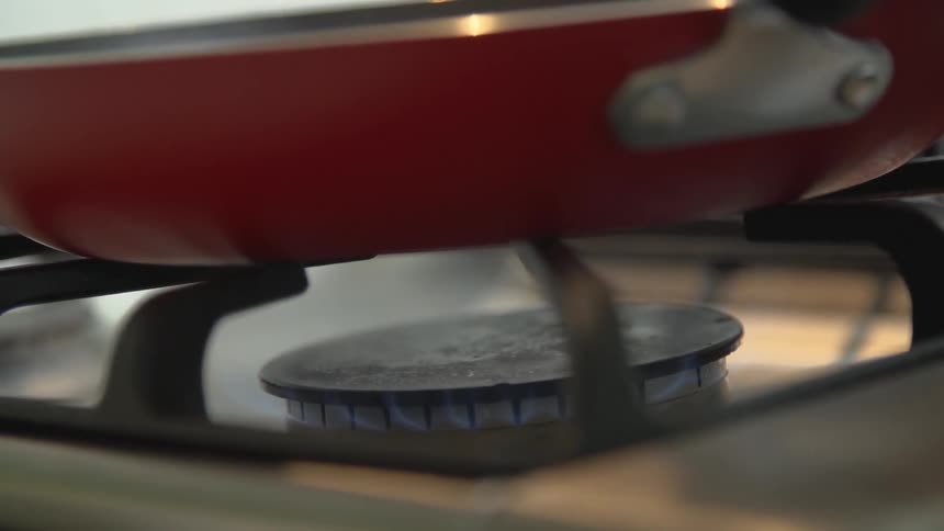 A stove heating a pan with fire
